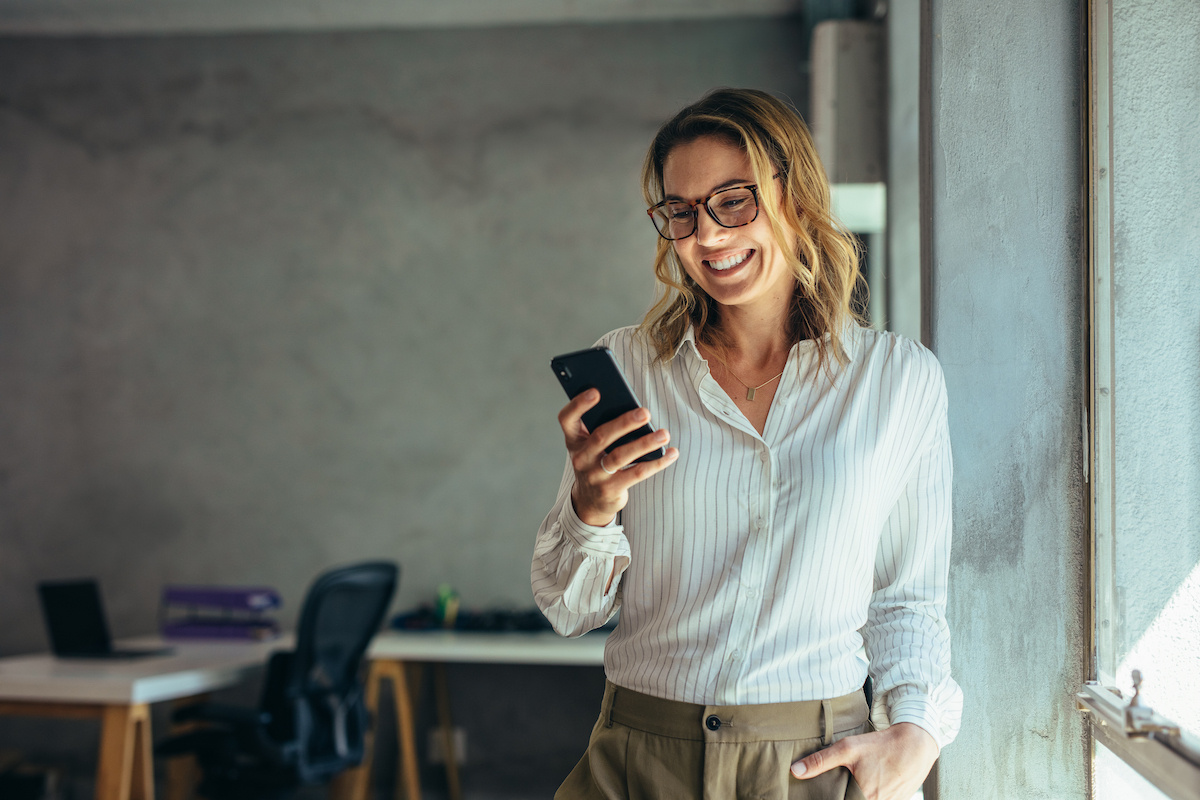 Smiling,Businesswoman,Using,Phone,In,Office.,Small,Business,Entrepreneur,Looking